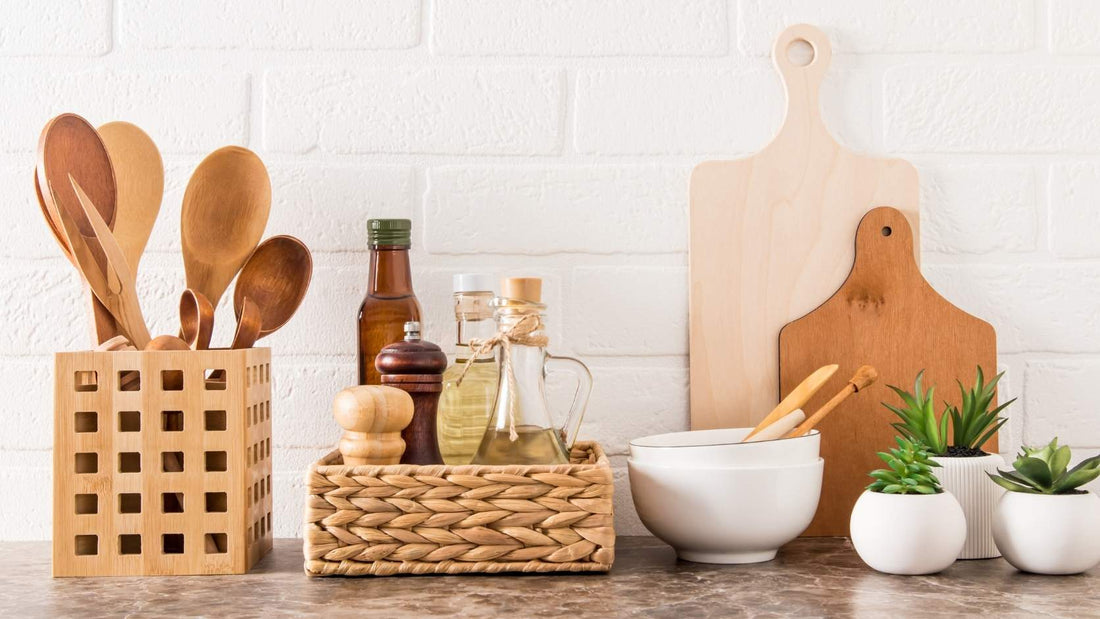 Wooden utensils, cutting boards, ceramic bowls, glass jars, and potted herbs on a countertop
