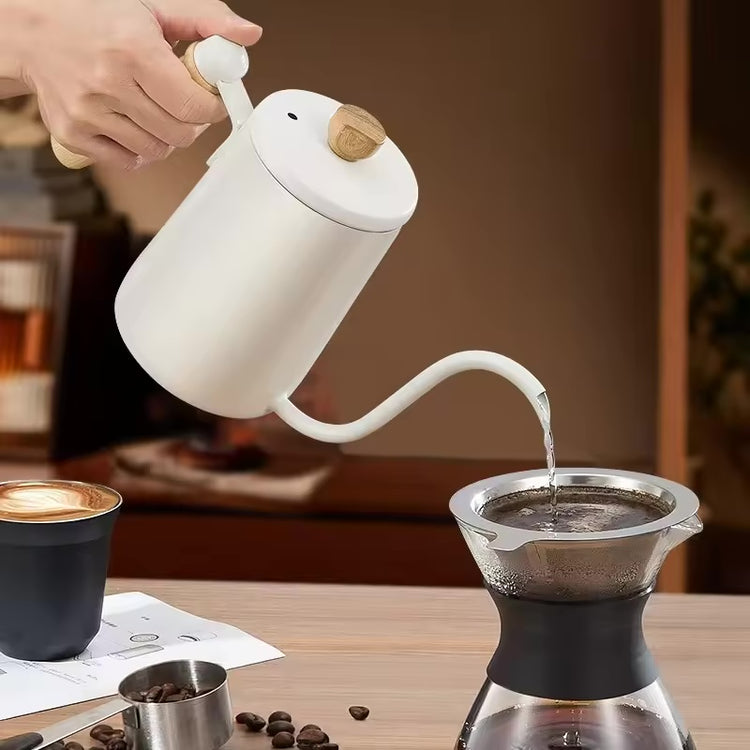 Cream-white gooseneck kettle pouring water into a metal coffee filter.