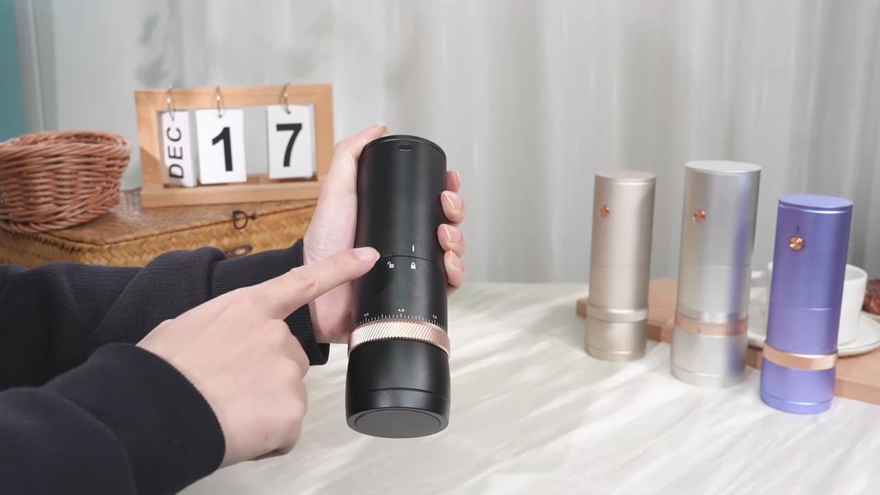Short silent demonstration of unlocking a silver rechargeable coffee grinder, removing the grounds cup, inspecting ground coffee and turning the adjustment collar.